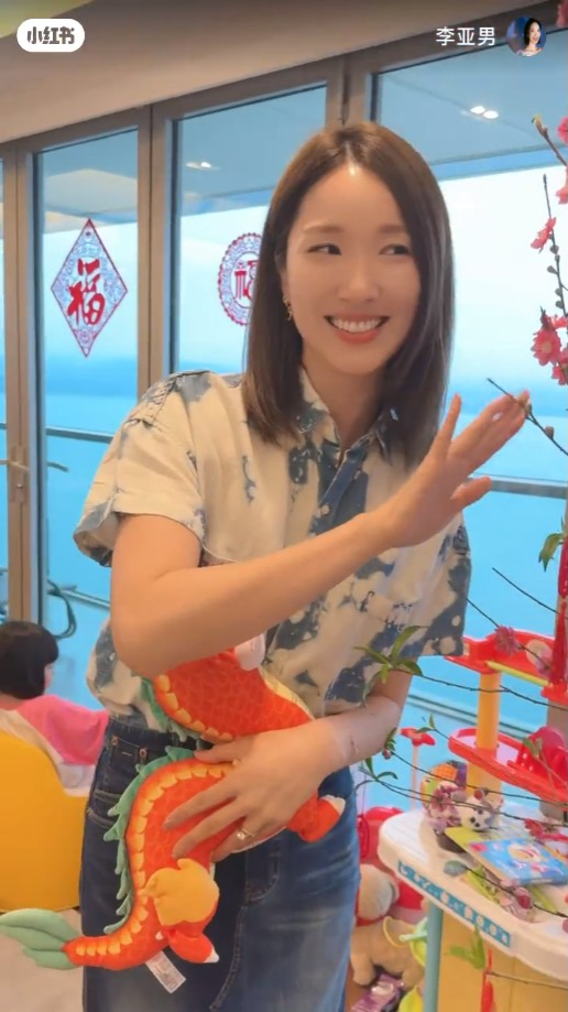 李亞男身後可望見海景。