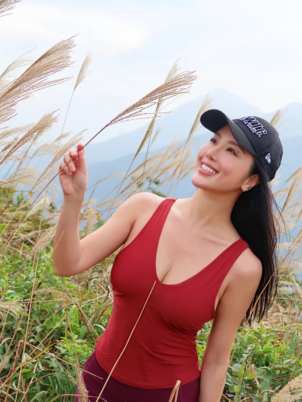 崔碧珈手持芒草甜笑仰望,構圖優美。