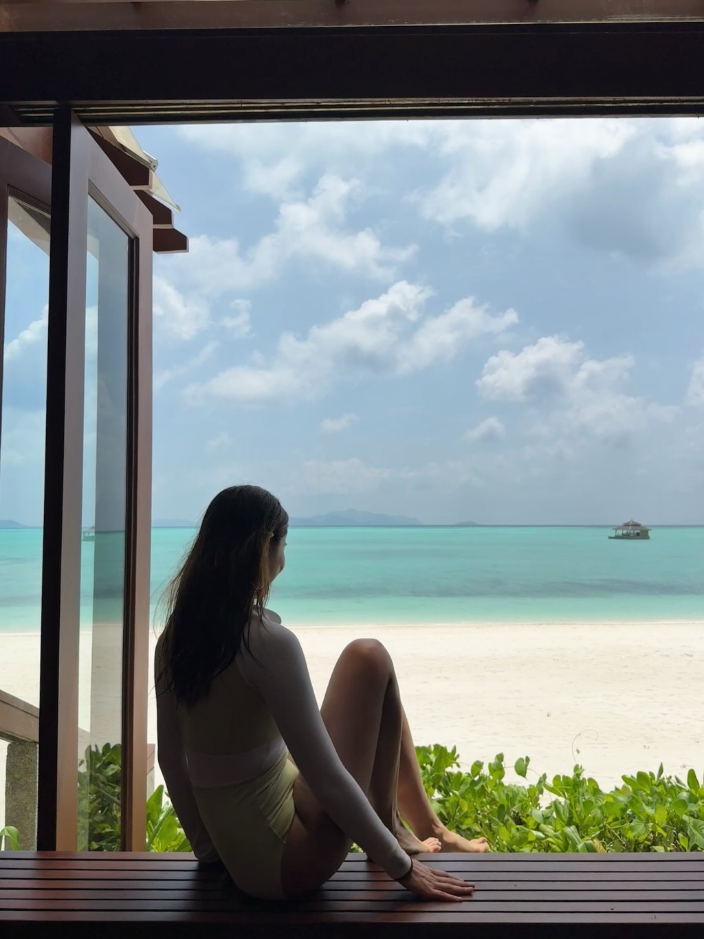 伍樂怡坐在度假屋中，靜靜欣賞眼前遼闊的海景。