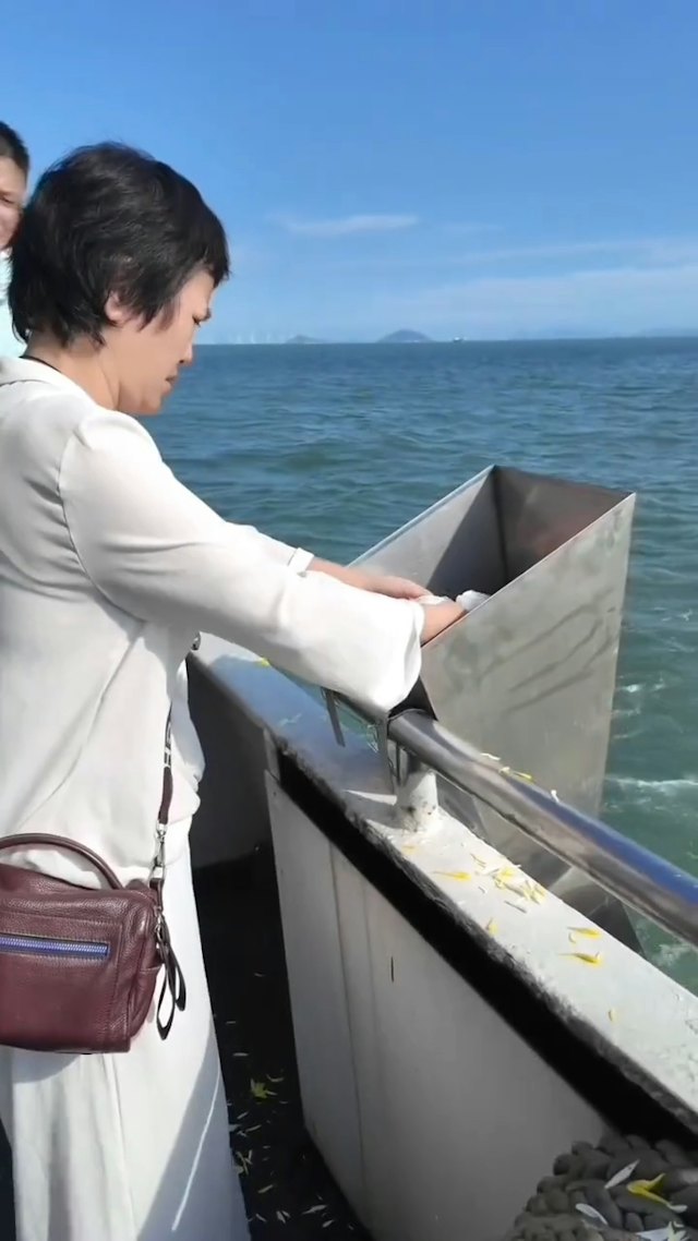 湯利萍親手將丈夫的骨灰撒入大海。