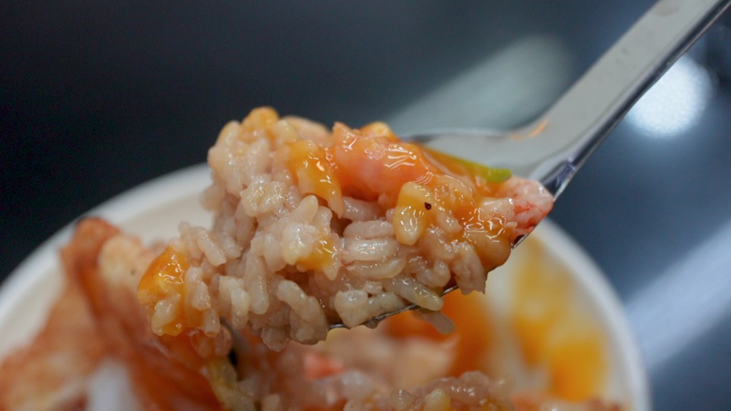 吳業坤在街頭品嚐熱騰騰的蝦仁飯,對這款老字號美食給予好評。
