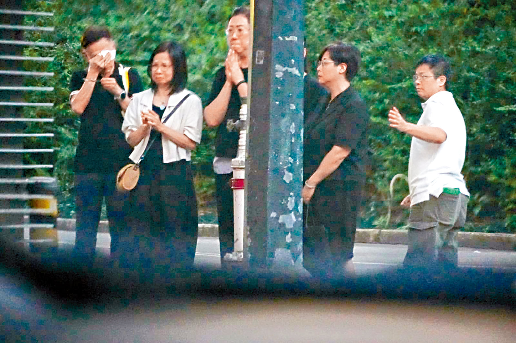 潘小文(右一)偕廿親友哭別。