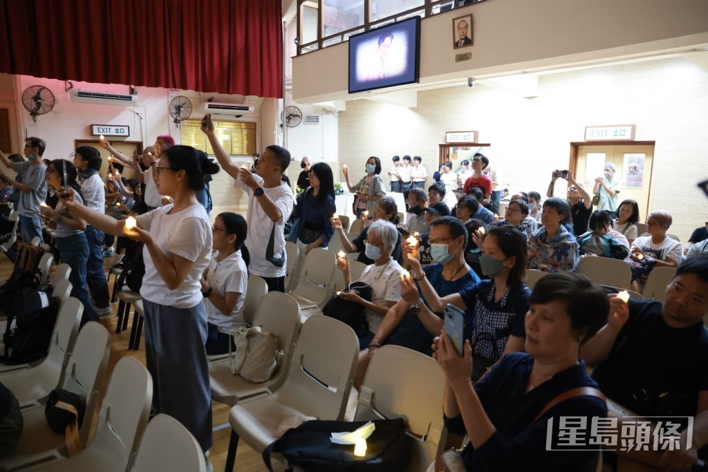 追思會上，市民點起燭光悼念。