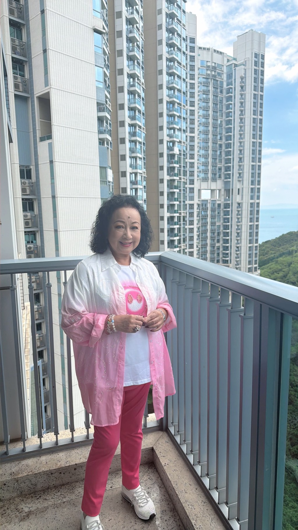 薛家燕站在露台上,身後住宅大樓景觀開揚。