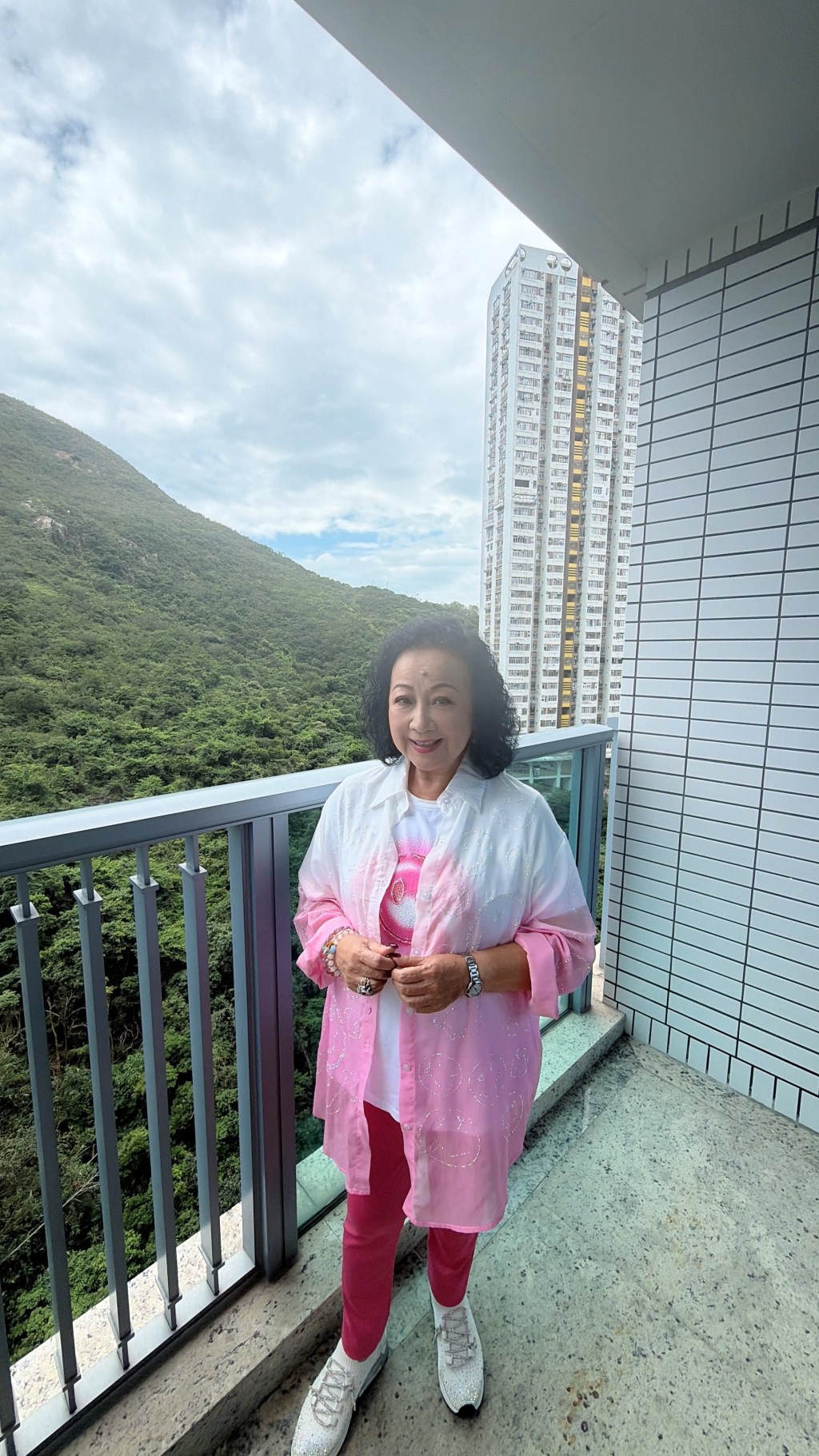 薛家燕從露台遠眺翠綠山景,顯得心曠神怡。