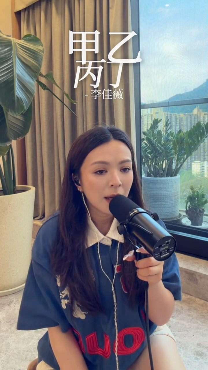 JW王灝兒在客廳落地窗前專注練歌,室內空間寬闊且樓底高。