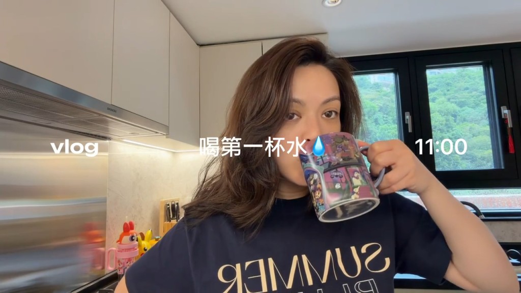 JW王灝兒在開放式廚房飲水拍片,廚房設備新穎齊全,窗外可見山景。