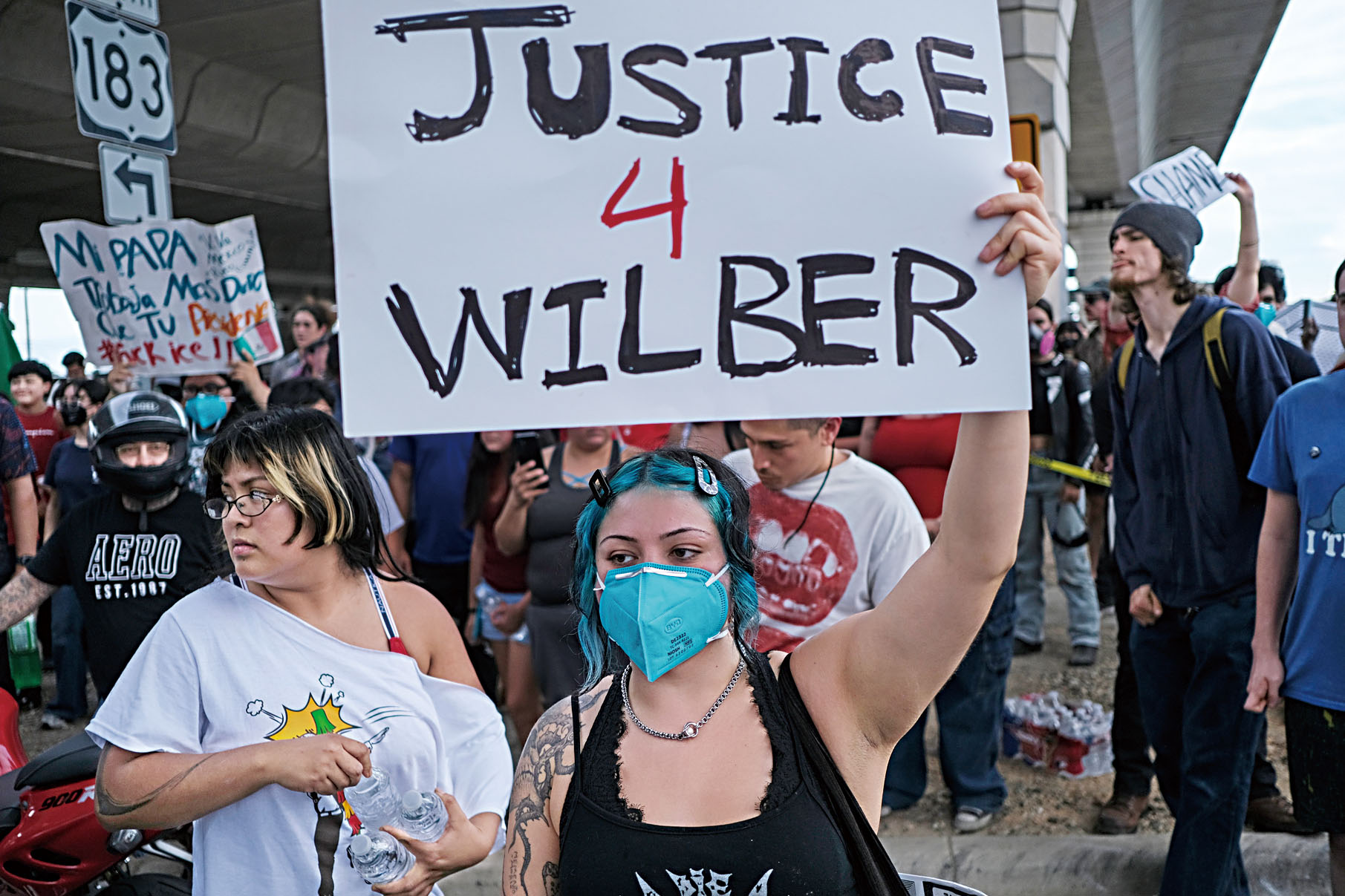 民眾在事發現場聚集和舉牌抗議，寫著被槍擊者的名字Wilber。美聯社