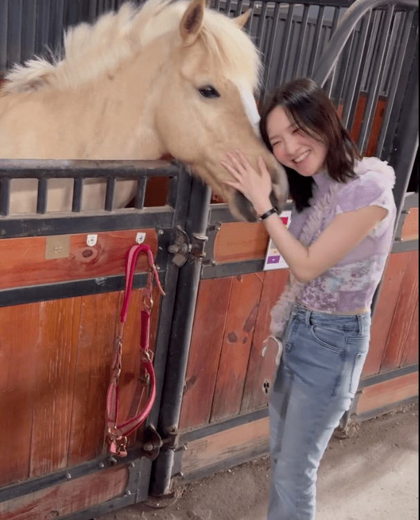 林欣彤與馬匹互動,展現燦爛笑容。