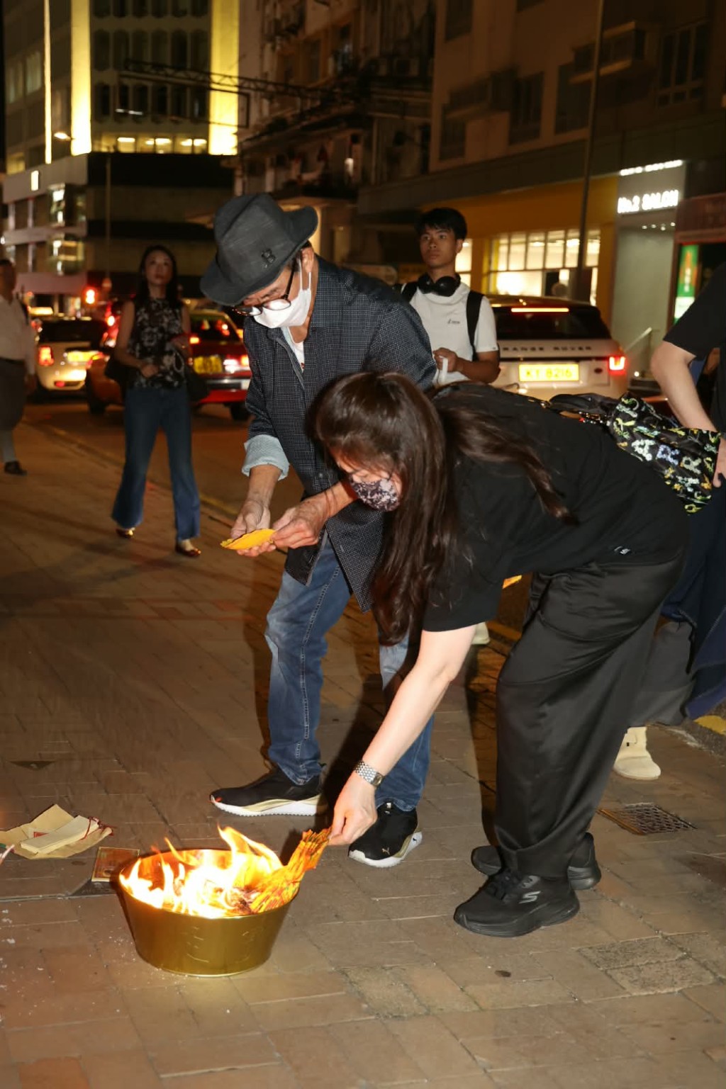 兩人開始燃點香燭及焚燒祭品。