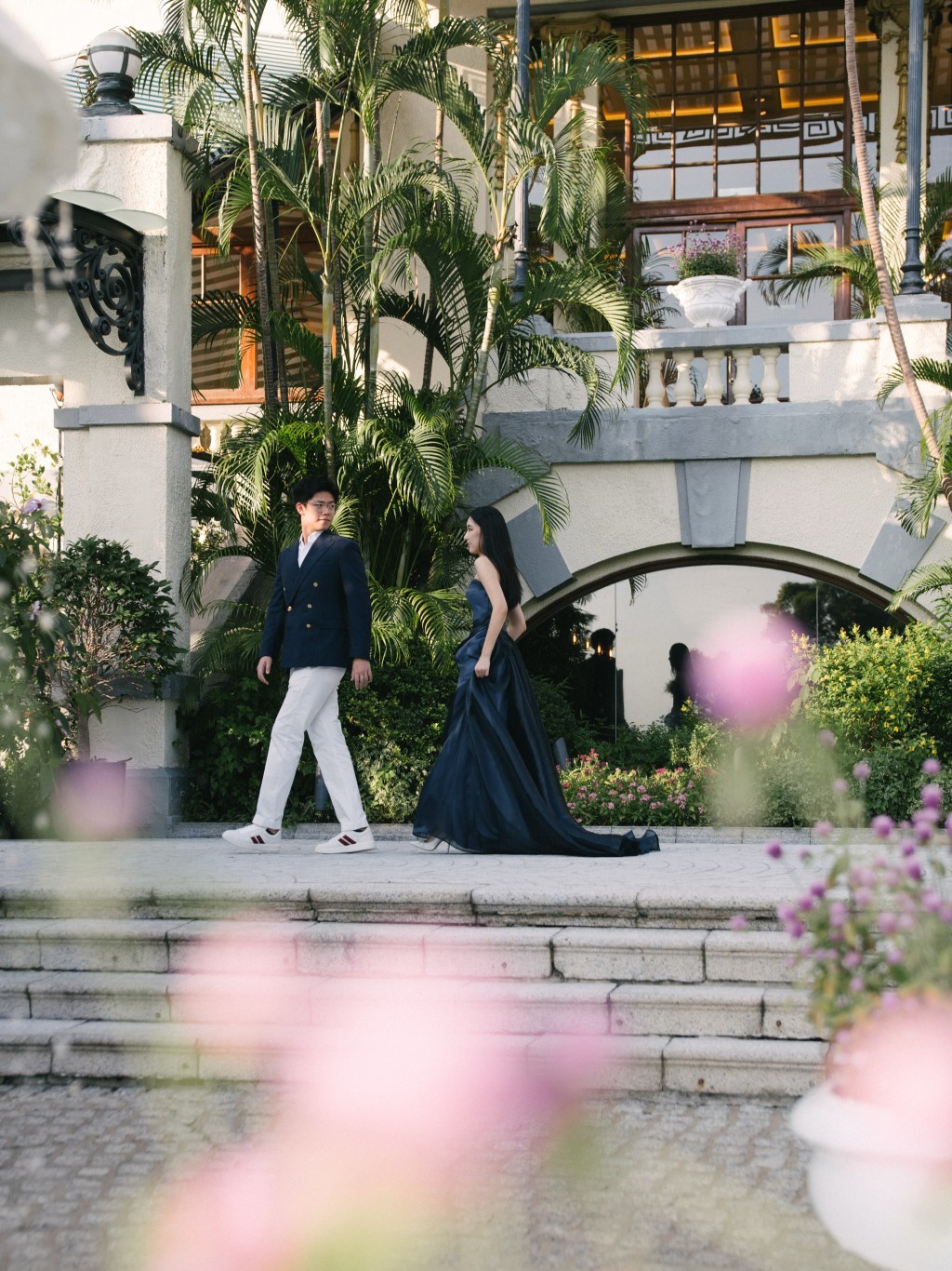楊培琳身穿深藍色拖尾晚裝,與未婚夫在花園中漫步對望。