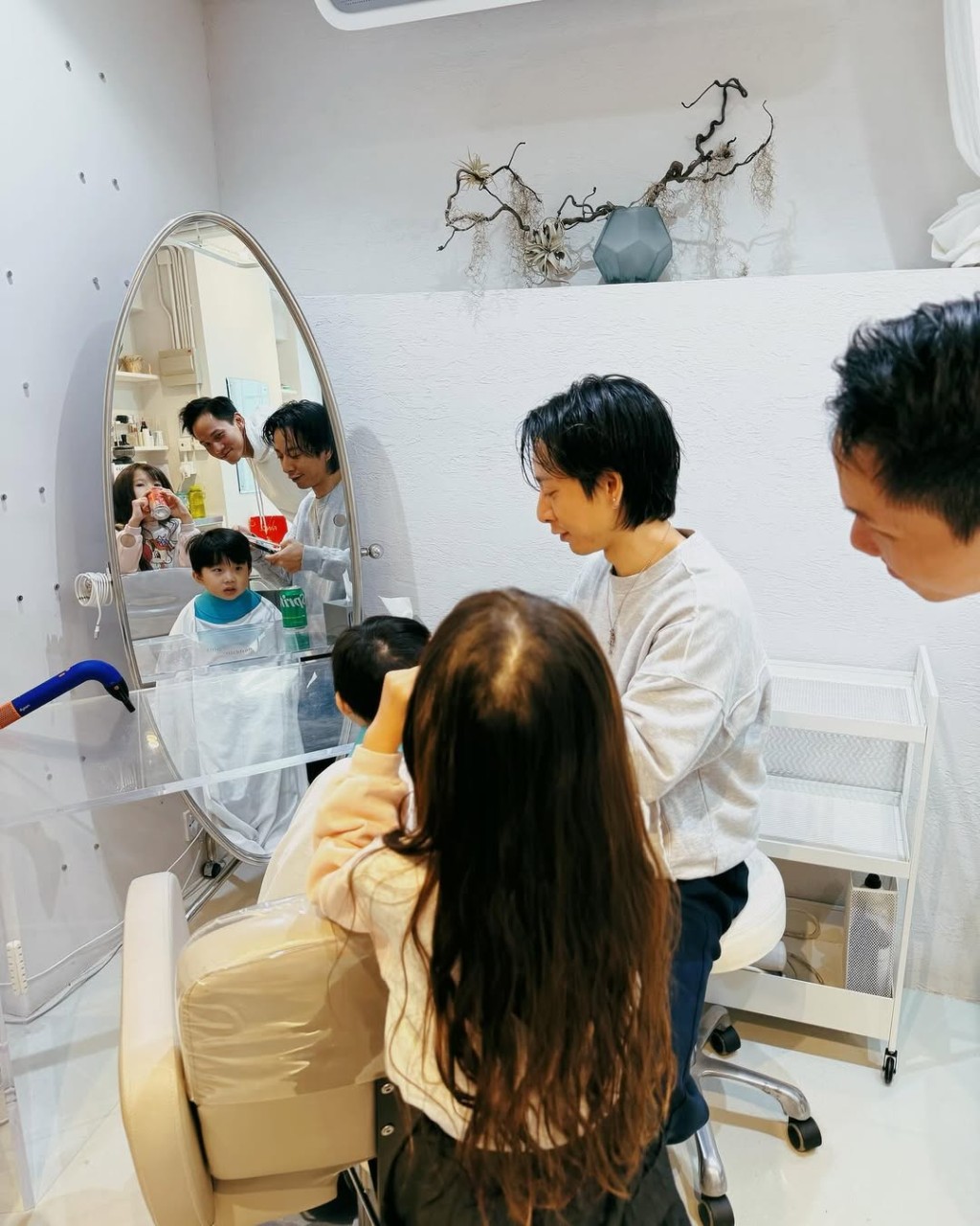 吳若希和丈夫帶子女去理髮,她在髮型屋打卡,鏡中倒影可見女兒樣貌與她相似。