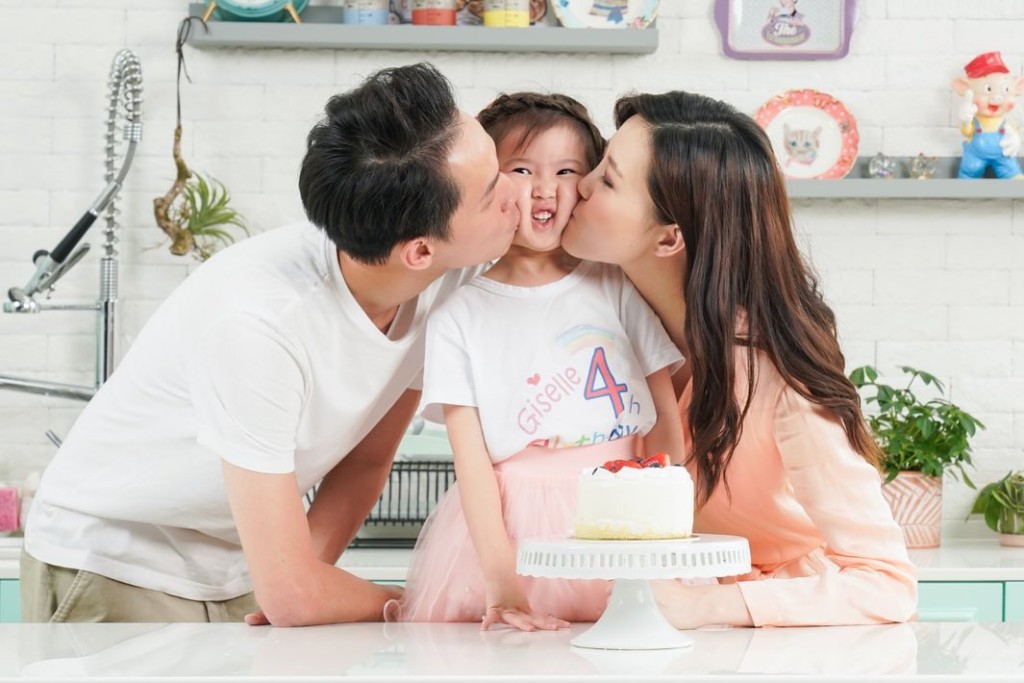 Giselle 4歲生日時,被父母親吻拍照,壽星女一臉無奈。