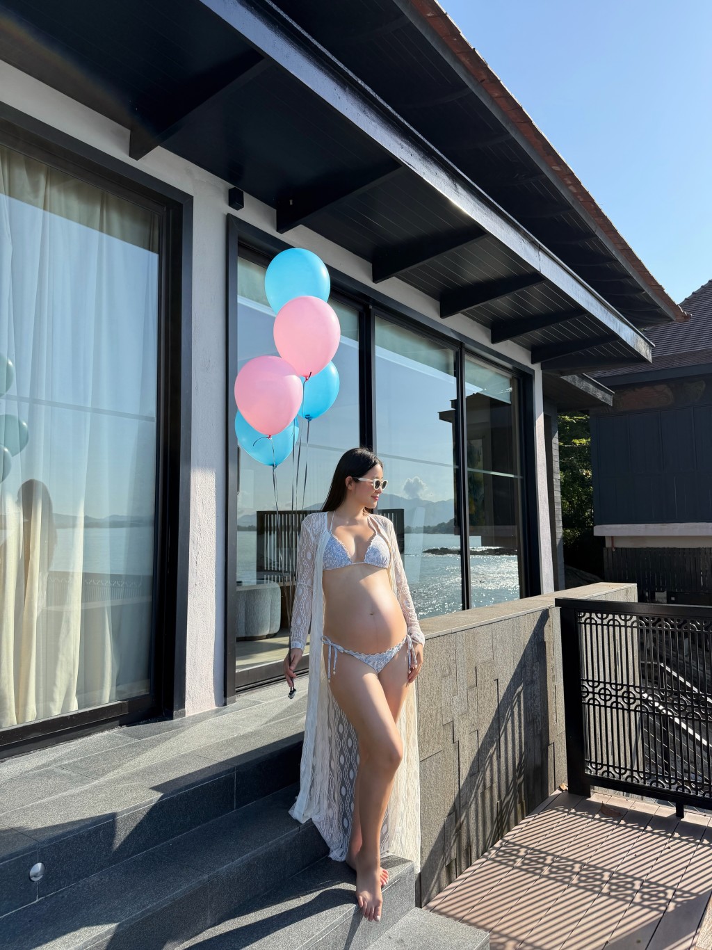 在海邊別墅,黃碧蓮手持粉藍氣球,穿著閃亮比堅尼展現身材。