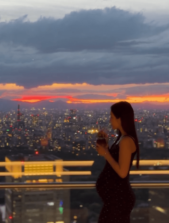 在東京頂級酒店露台,黃碧蓮以日落為背景,輕撫孕肚喝飲品,畫面唯美幸福。