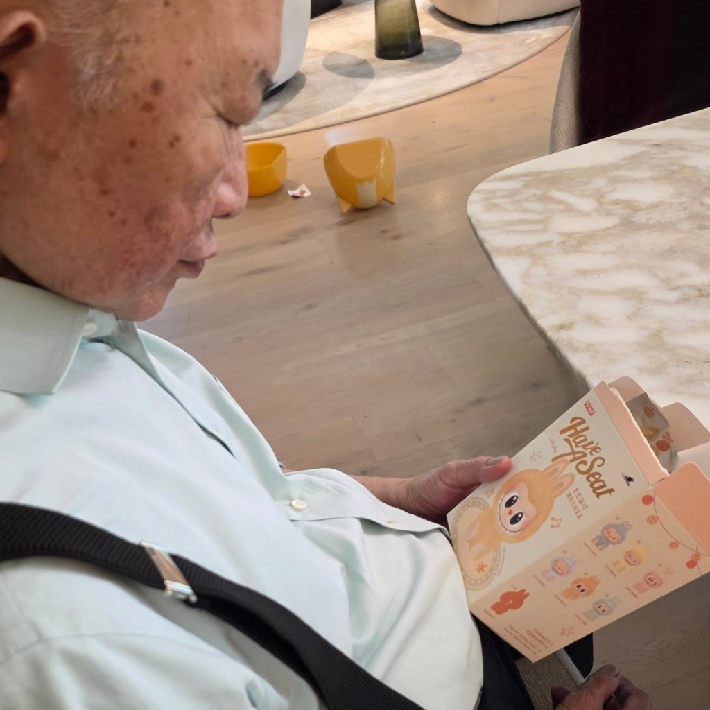 吳宇森對孫女的玩具Labubu也充滿好奇,認真研究。