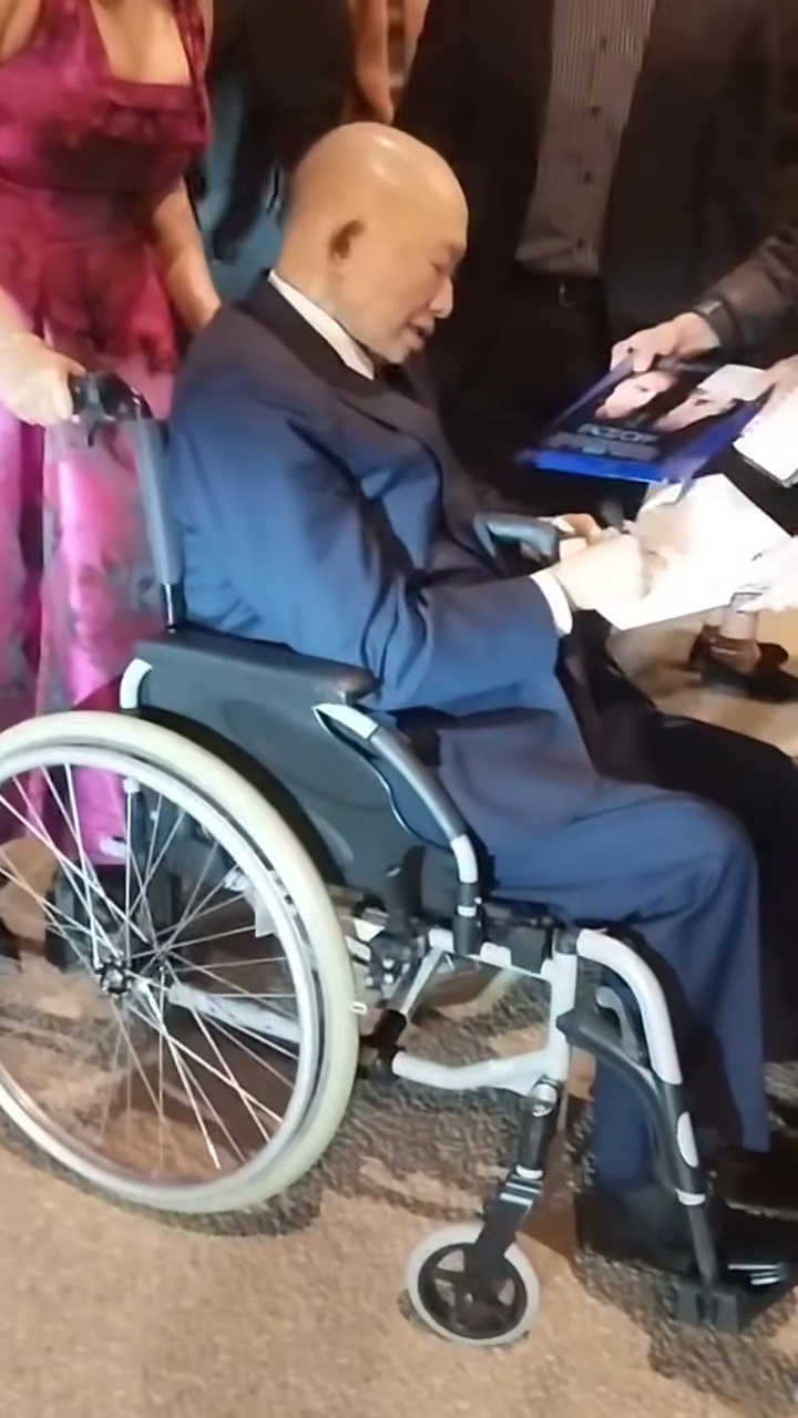 吳宇森坐在輪椅上逐一為影迷簽名,表現親民。