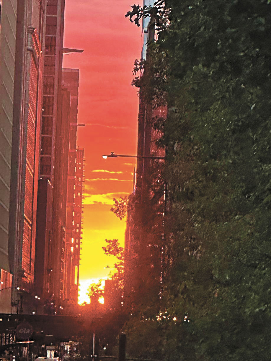 秋分懸日漫天的紅雲灑滿所有東西向的街道，呈現出一副無法用語言形容的壯麗奇觀。梁敏育攝