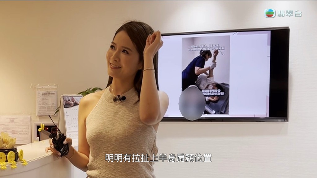 主持指著店內電視播放的示範片，證明技師有拉扯上半身的動作。
