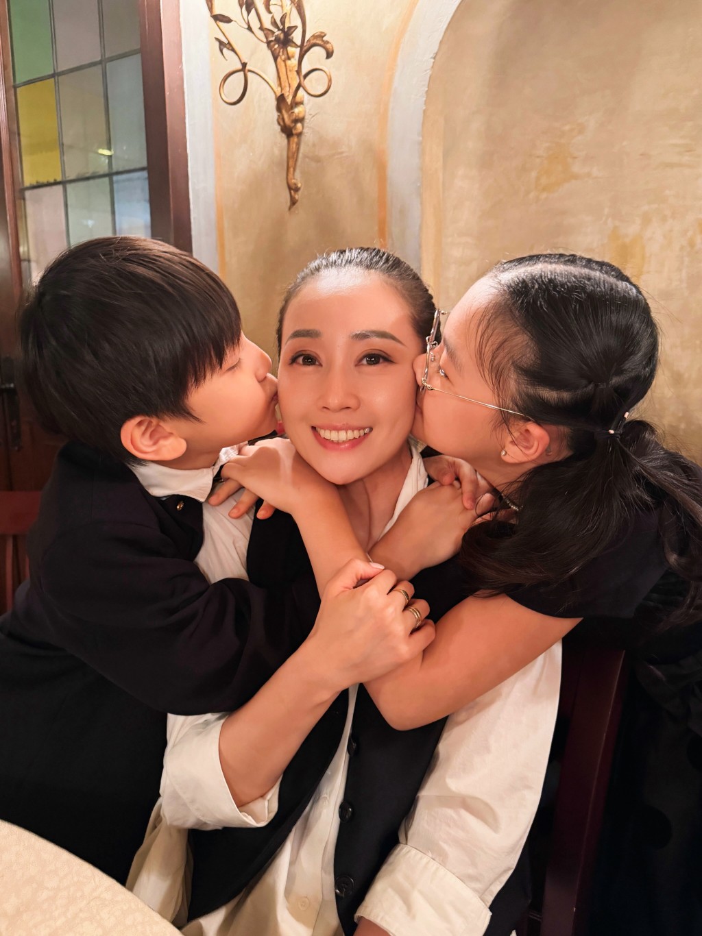 一對子女左右親吻媽咪，任祉妍露出甜蜜笑容。