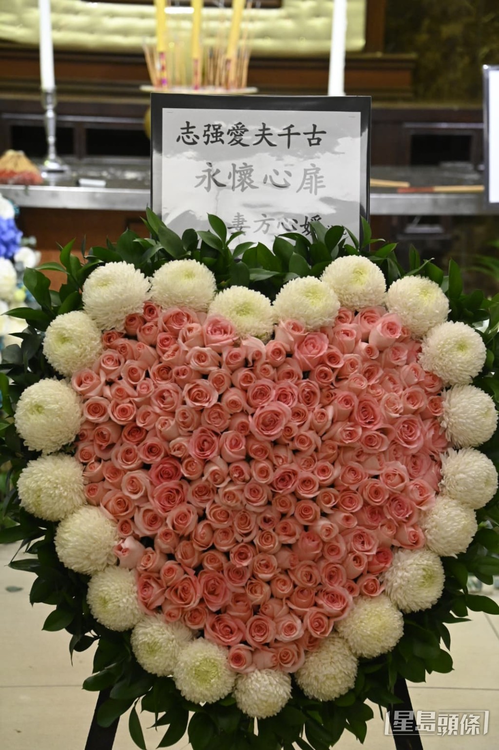 遺孀方心媛的心形花牌上寫著「永懷心扉」,表達對亡夫的思念。