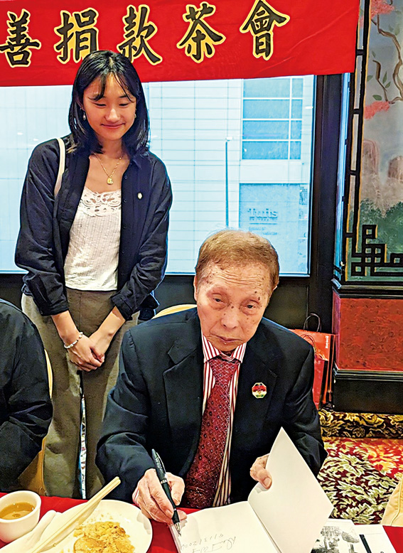 黃官羨元老在贈送給吳市長唐人街聯絡員林天琪的新書上簽名。