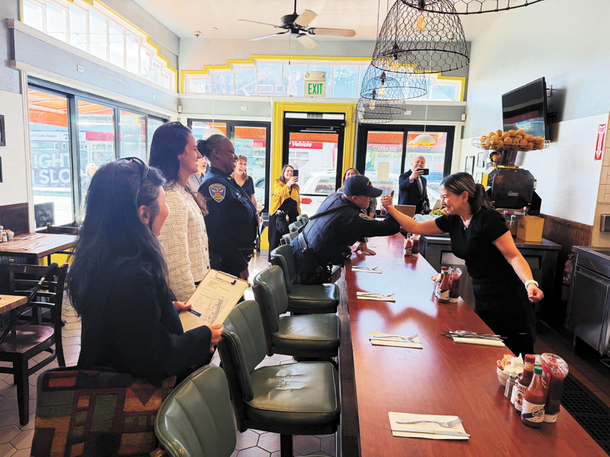 9月初新派駐寶多拉的巡邏警員李海（左）走訪餐館時與女店員熱情互動。記者蘇婕雅攝