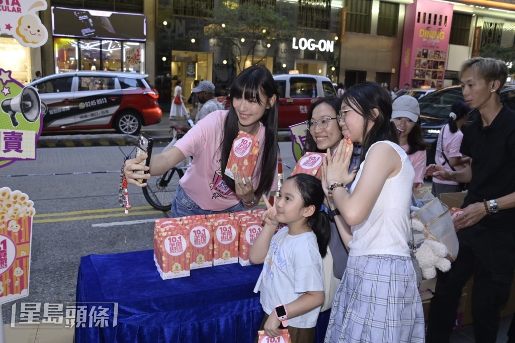 王丹妮與途人進行自拍互動。