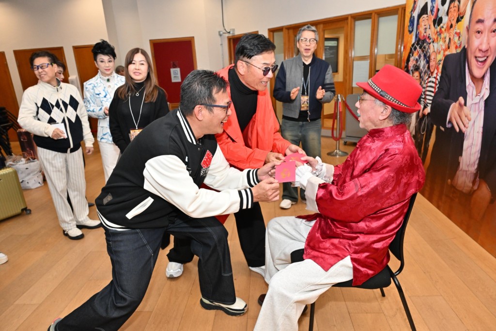 黃日華、苗僑偉向盧海鵬送上利是。