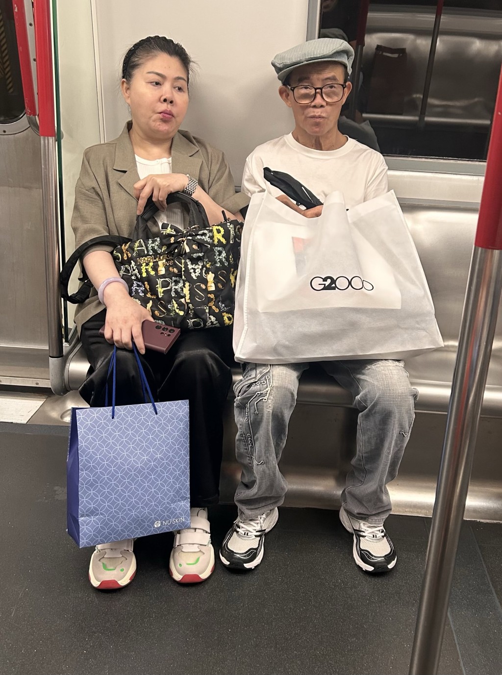 照片顯示梅啟明似乎剛購物完畢。