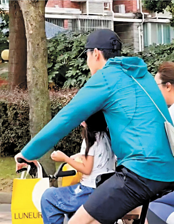 胡歌騎車帶娃，妻子騎車隨行 。網上圖片
