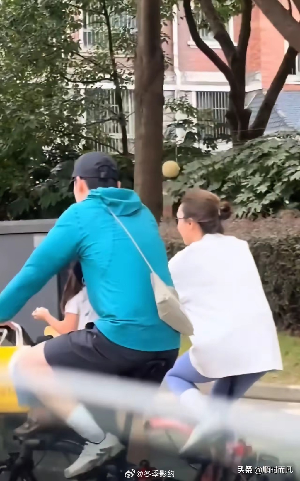 胡歌在踩單車時為太太孭著手袋。