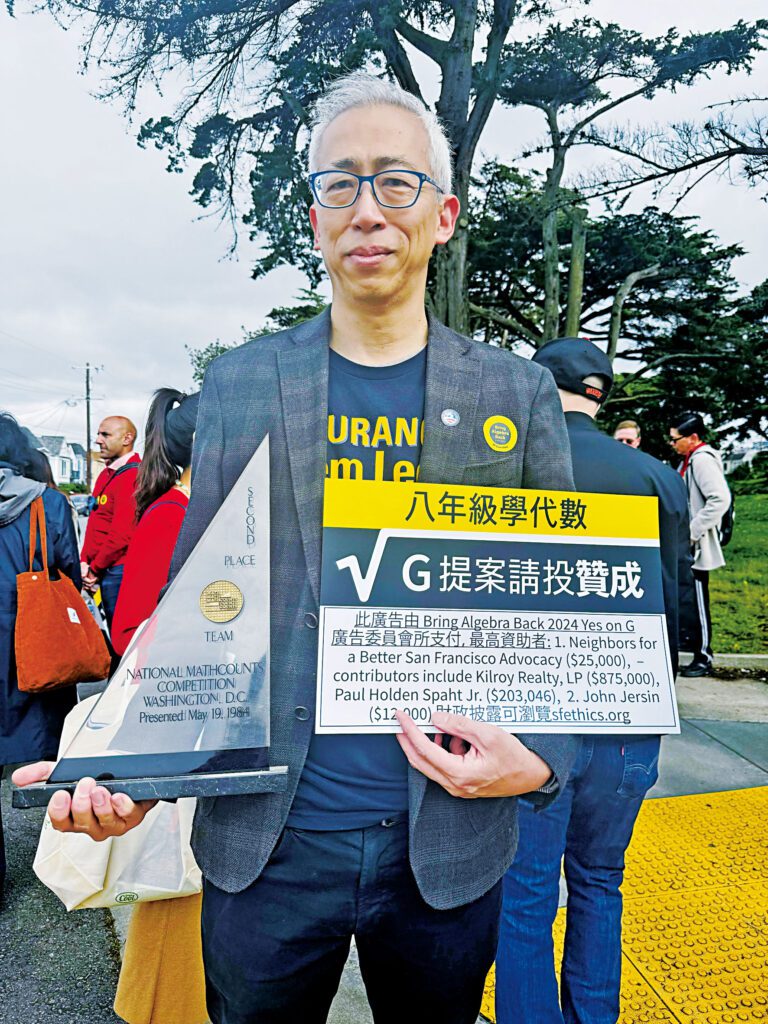 教委候選人林灼世2024年手持支持八年級代數G提案的標語及昔日參加全國MATHCOUNTS數學競賽所得獎座。記者蘇婕雅攝
