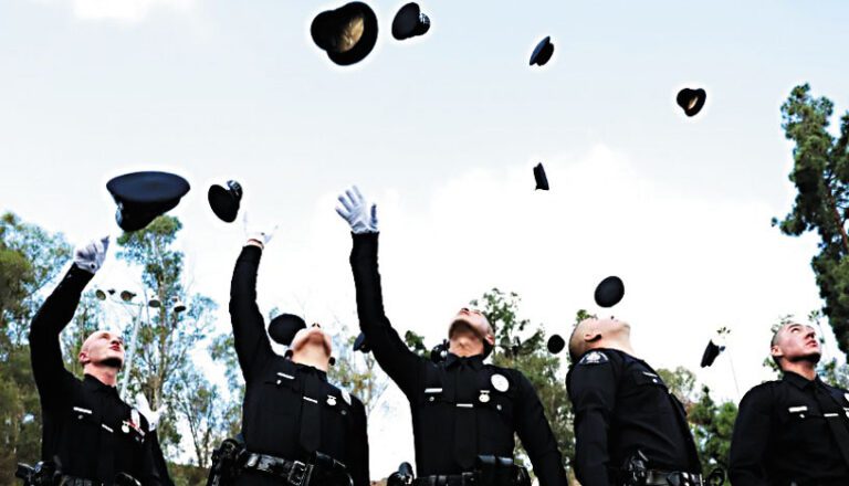 在洛杉磯警察學院畢業典禮上，新任警察將帽子拋向空中。洛杉磯時報