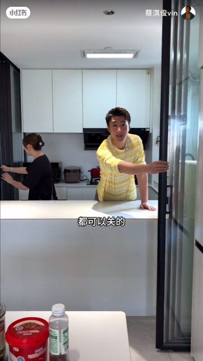 蔡淇俊介紹家中的半開放式廚房，活動玻璃移門有助阻隔煮食油煙。