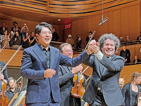 紐約愛樂團指揮Gustavo Dudamel與鋼琴家郎朗10月1 日演出後謝幕，後為樂團首席小提琴手黃欣，觀眾掌聲如雷。