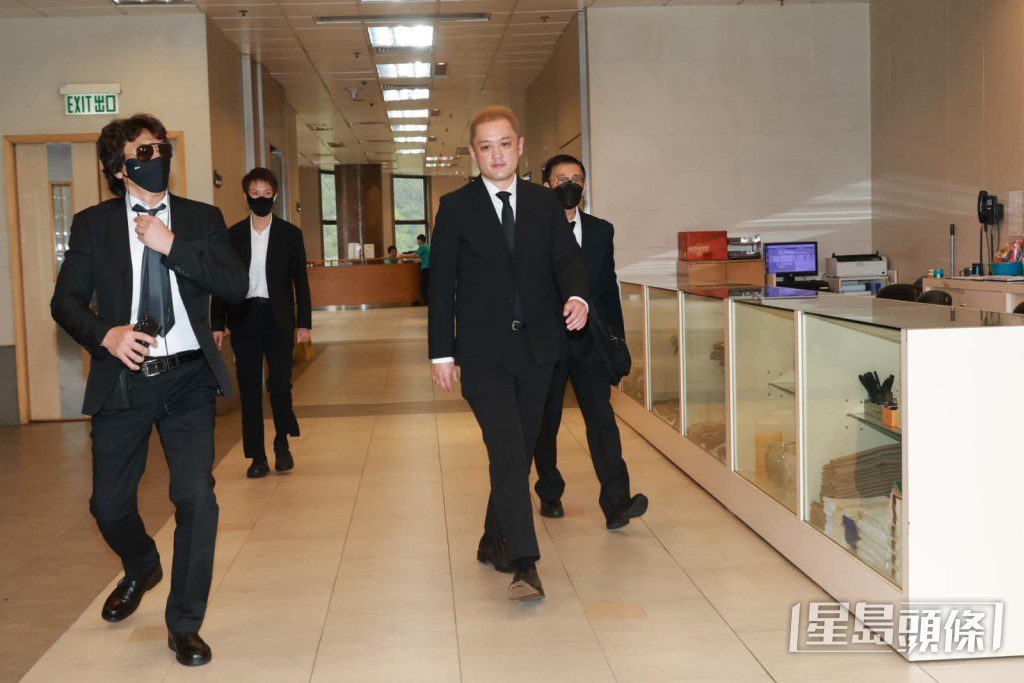 李泳漢在「保安隊」護送下抵達殯儀館。
