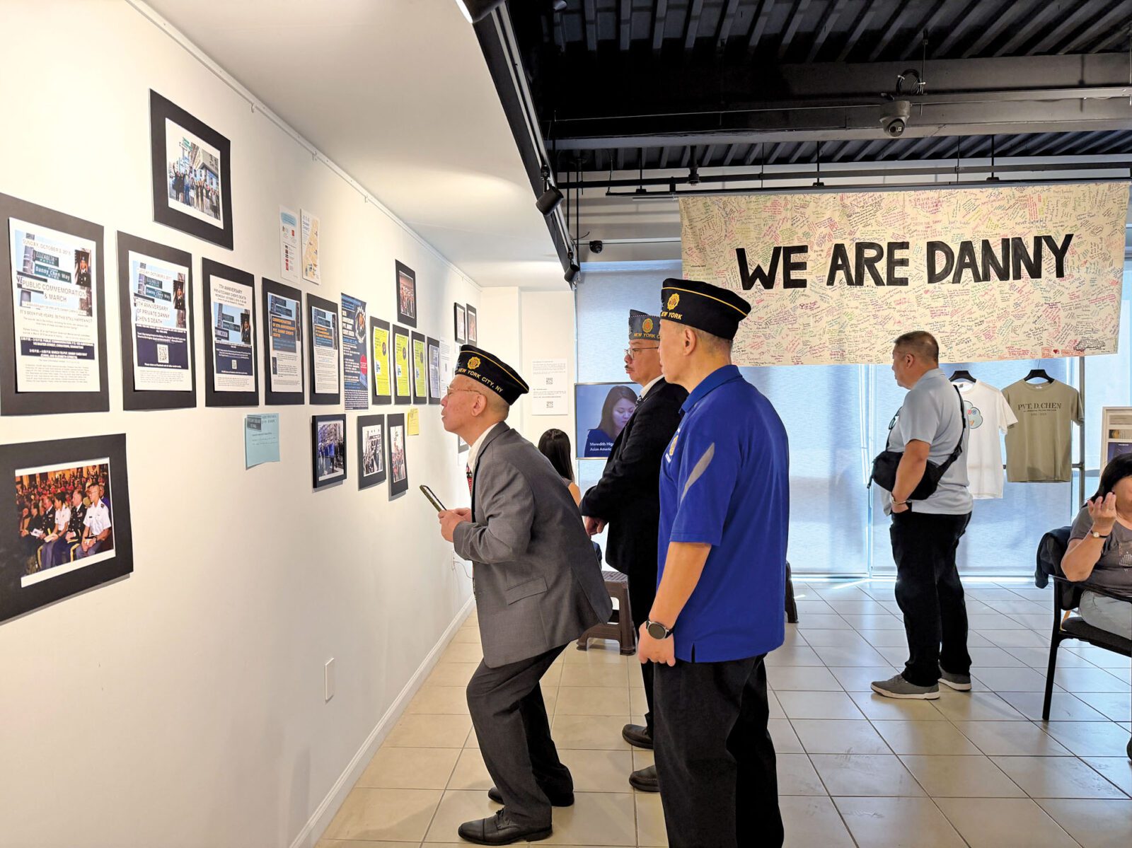 特展上，華人退伍軍人陳煥明曲著身子仔細參觀，而橫額「We Are Danny」密密麻麻的簽名充滿激勵。