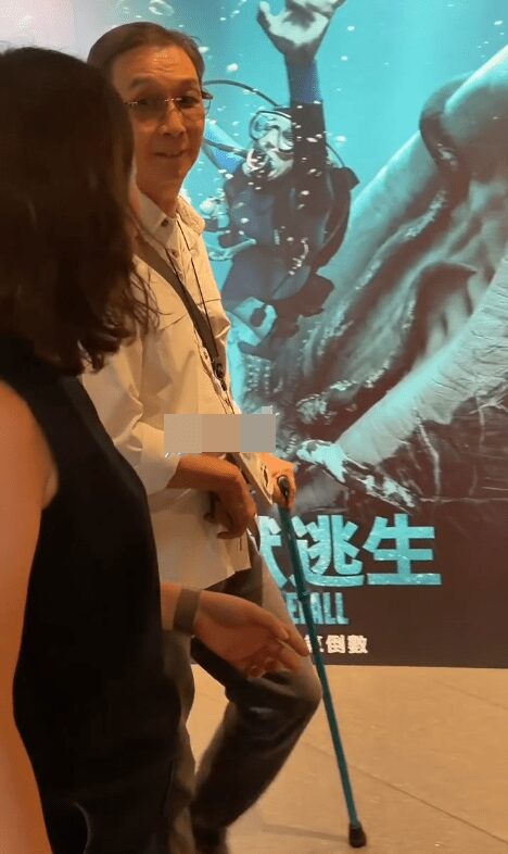 吳尊和兒子在球場上投入地觀看比賽。