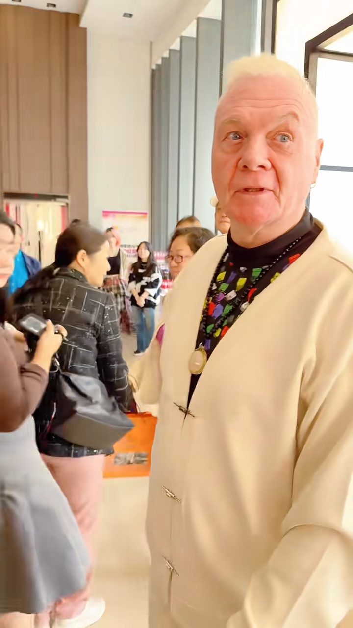當時白髮蒼蒼的何麥,身穿黑色衛衣配米白色針織外套,獨自步入會場。