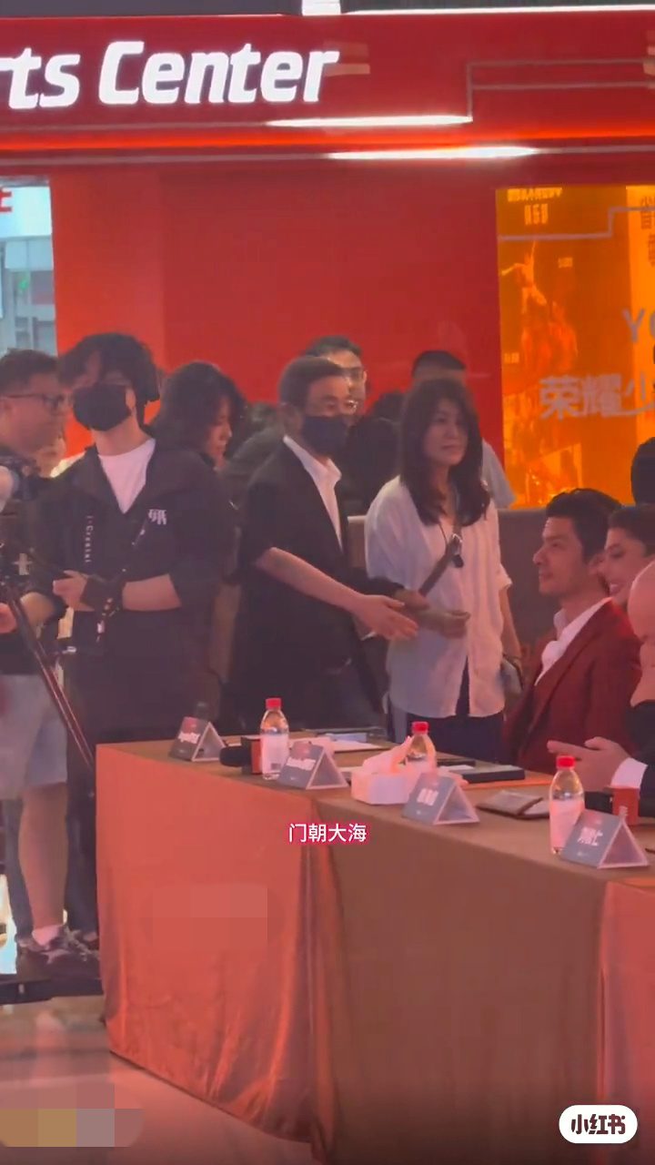 劉松仁由身旁女士攙扶,準備入座。