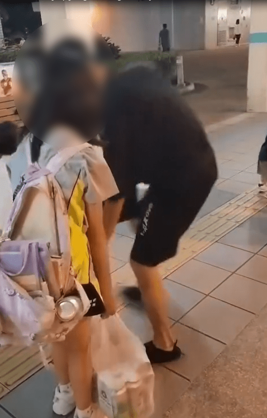 當街坊對父親的做法表示疑問時,父親突然轉身抽走女童手中的一袋啤酒。
