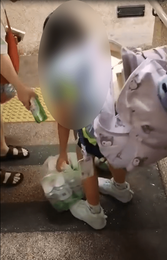 一名穿著校服的女童手提兩袋重物,正沿地下行人隧道上斜。