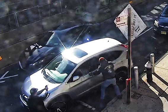 兩名幹員拔槍靠近汽車,其中一人揮拳砸碎駕駛座車窗。 NYPD