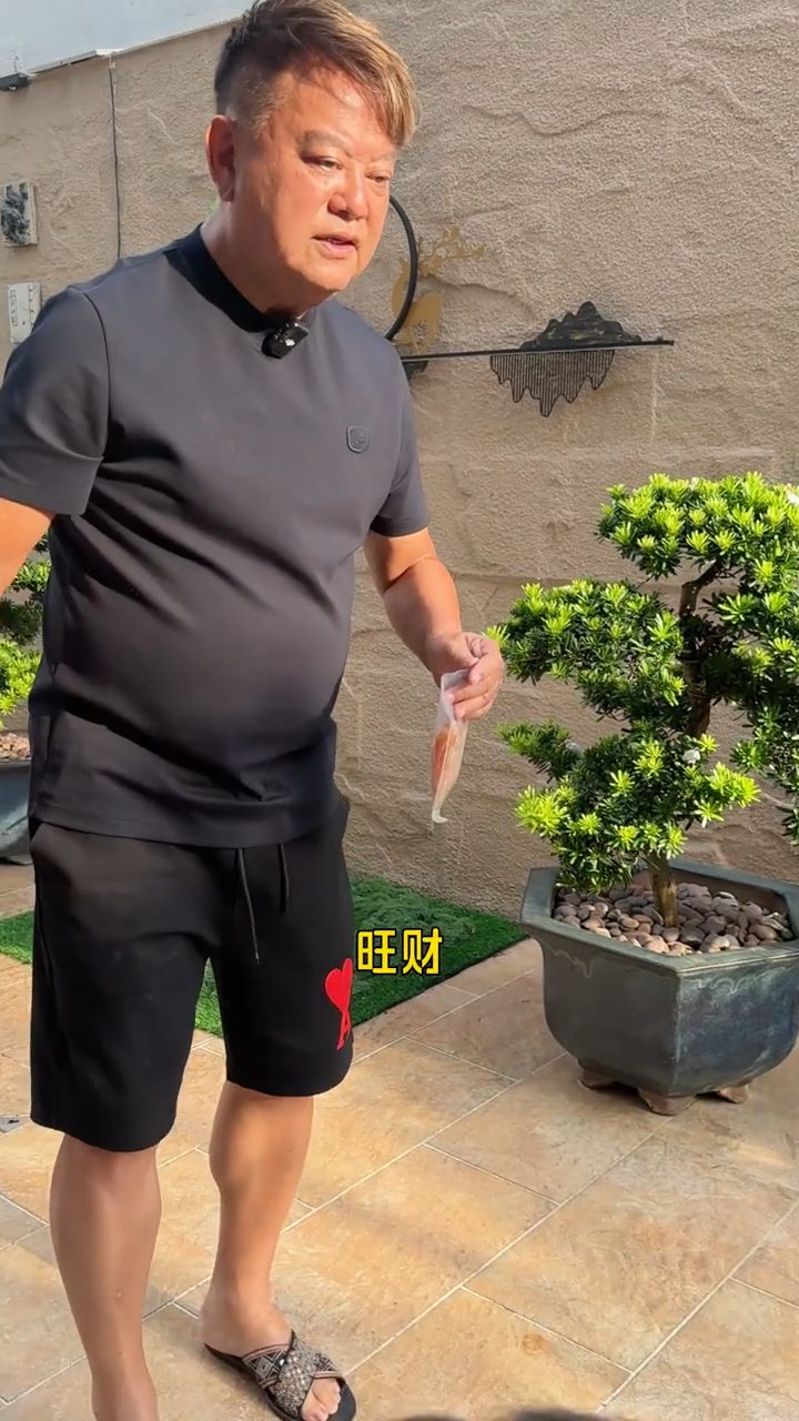 陳百祥一身休閒裝扮,在自家花園以零食訓練愛犬,並笑談家中地位。