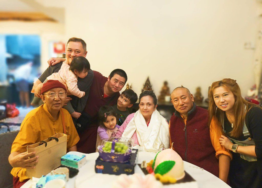 施明被三名孫兒圍繞,面露開心笑容。