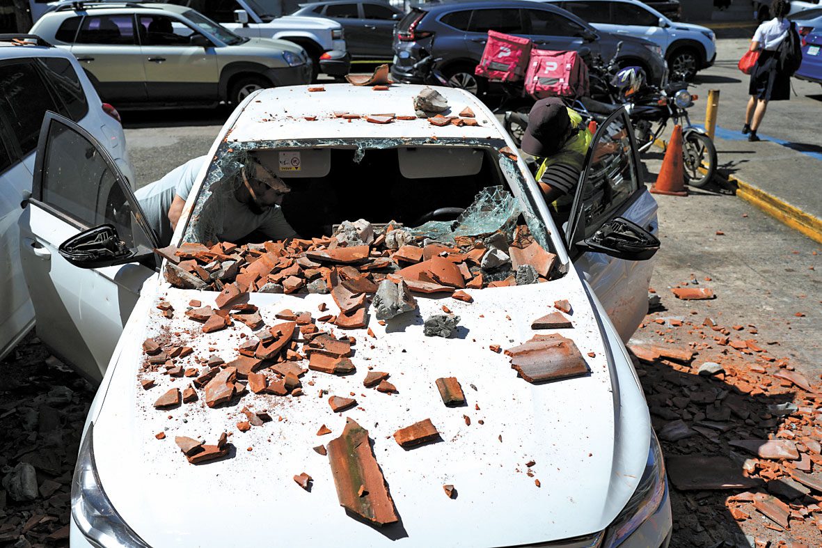地震導致屋瓦掉落砸中車輛。路透社