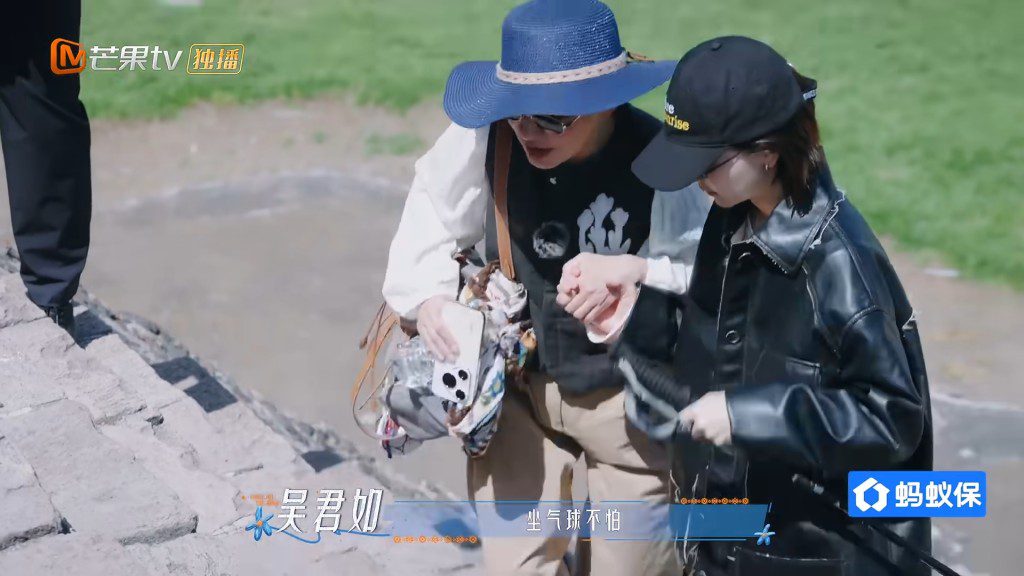 周冬雨緊牽吳君如的手,小心翼翼攙扶她沿陡斜石階下行。