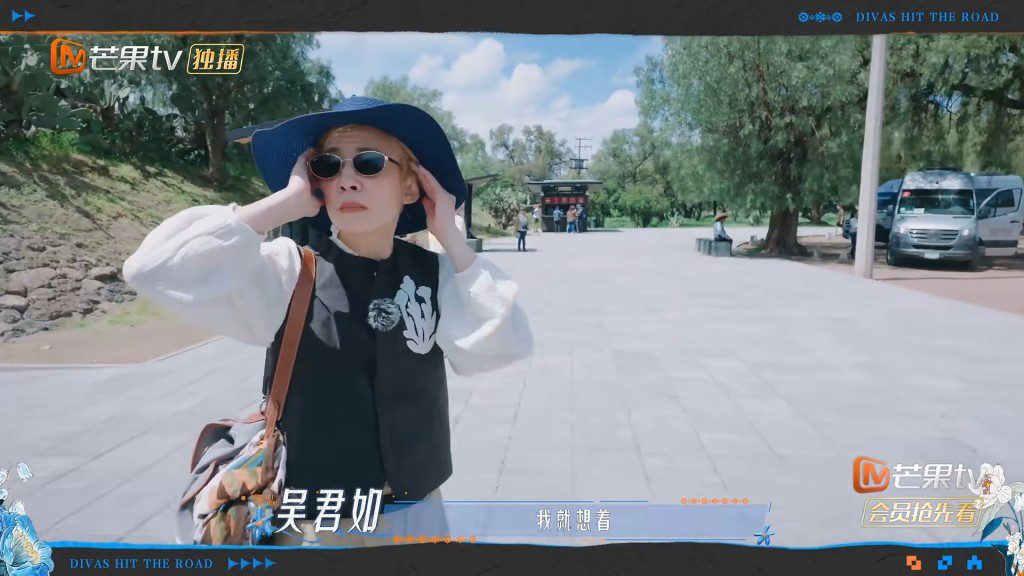 吳君如在返回旅遊巴途中雙手緊抱太陽穴,眉頭深鎖,步履緩慢。