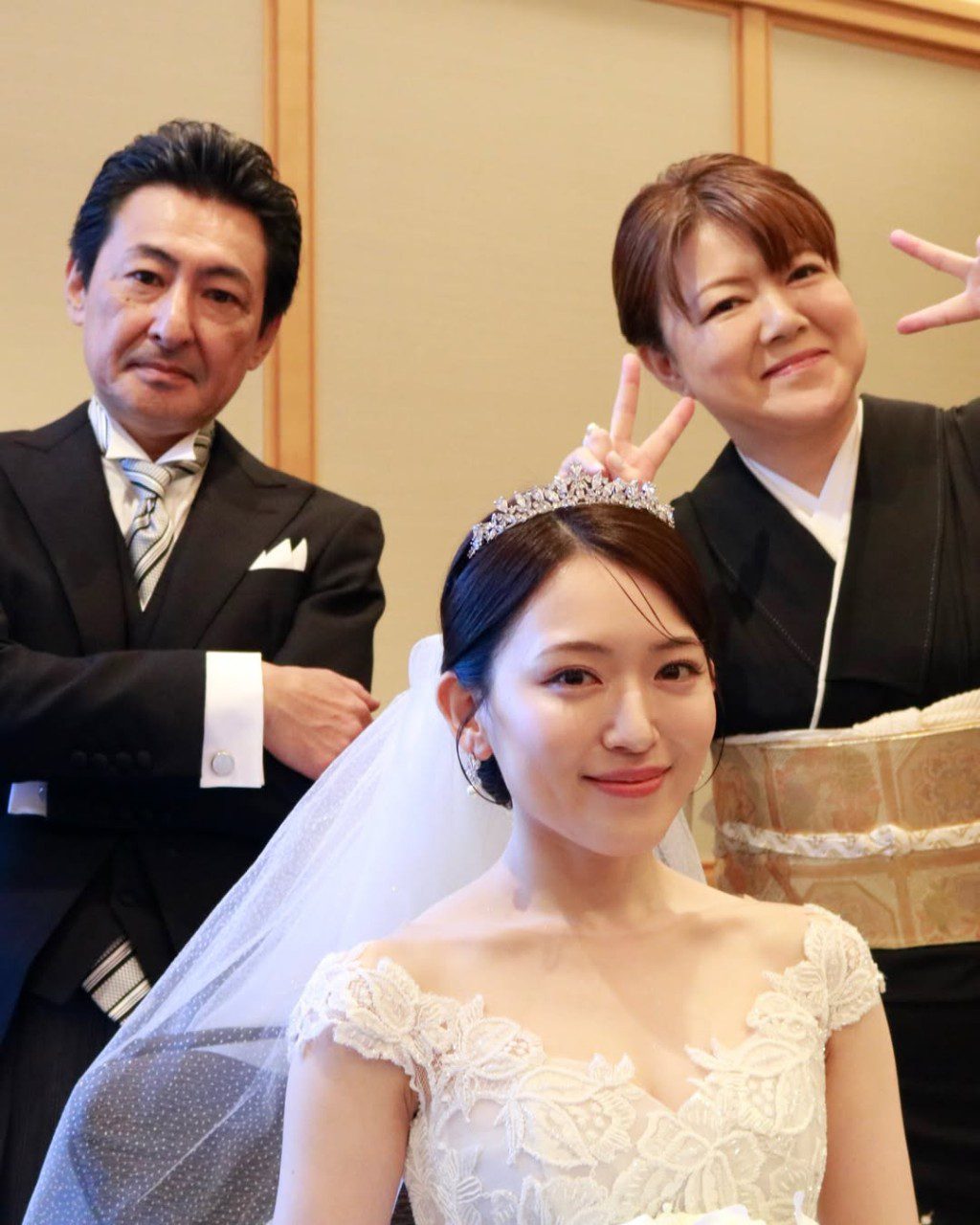 內田真由美與父母合照,媽媽在背後舉起V字手勢。